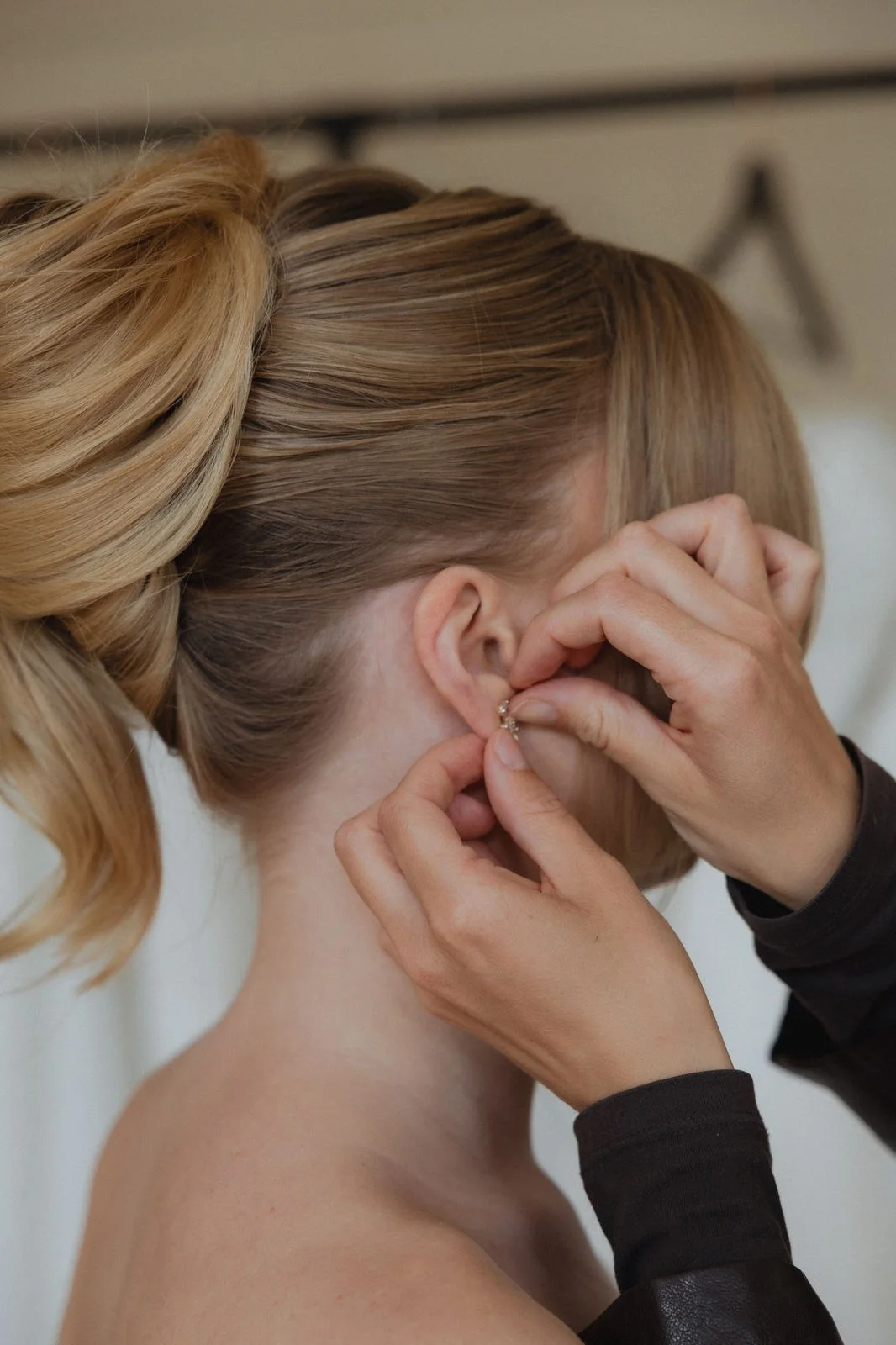 Das Love Edit Team richtet bei einer Braut mit Hochsteckfrisur den Schmuck