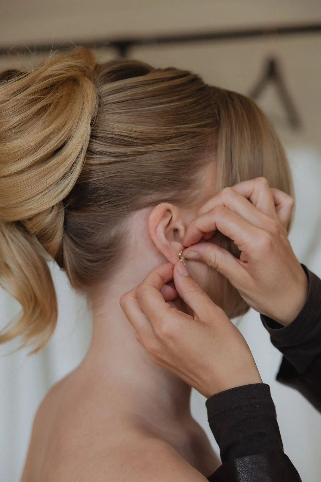 Das Love Edit Team richtet bei einer Braut mit Hochsteckfrisur den Schmuck